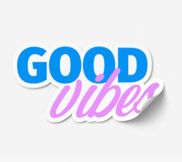 A die-cut vinyl sticker with the text 'GOOD vibes' in blue and pink script, featuring a white border and a subtle drop shadow on a light gray background.